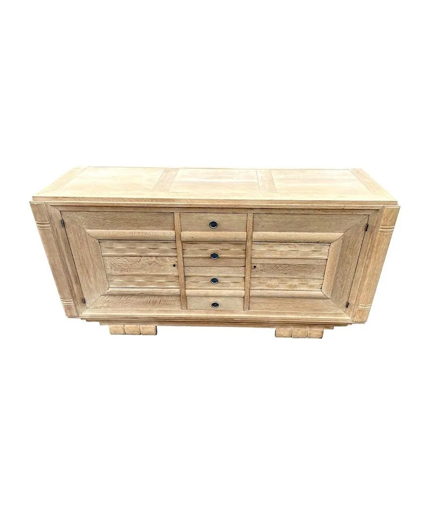 A French 1940s bleached oak sideboard in the style of Charles Dudouyt with two doors and four central drawers and relief front design