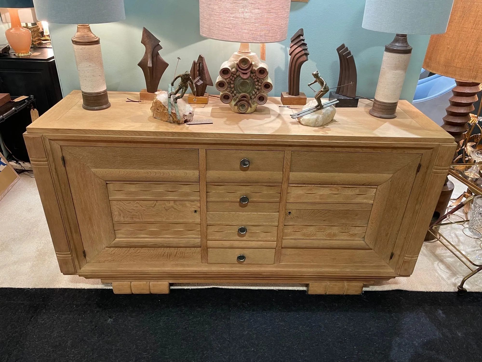 A French 1940s bleached oak sideboard in the style of Charles Dudouyt with two doors and four central drawers and relief front design