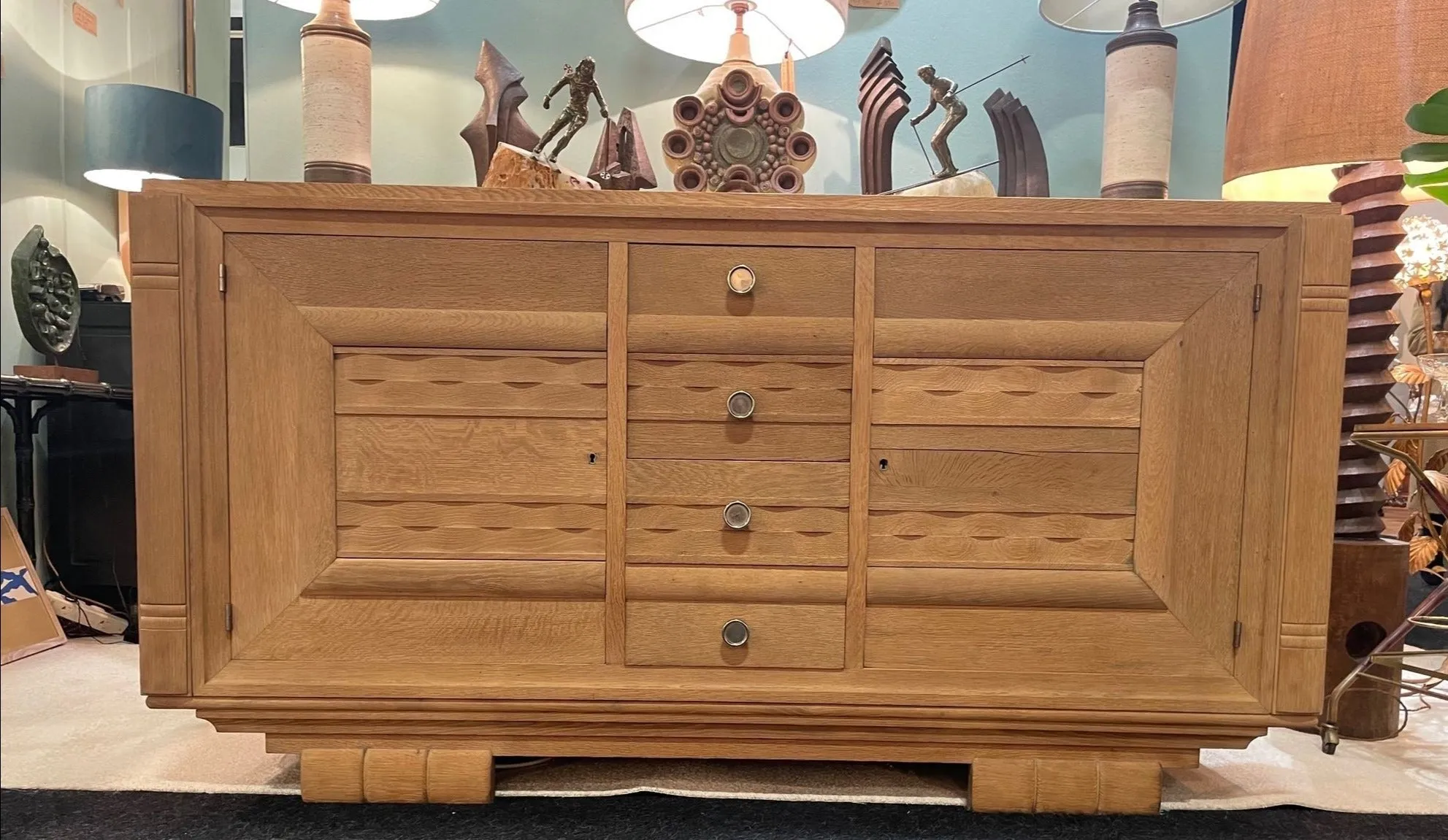 A French 1940s bleached oak sideboard in the style of Charles Dudouyt with two doors and four central drawers and relief front design