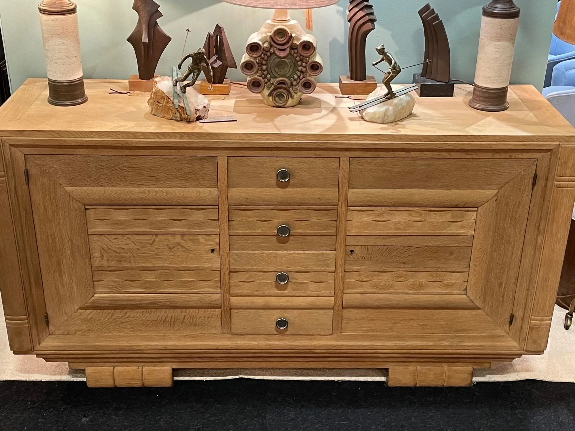 A French 1940s bleached oak sideboard in the style of Charles Dudouyt with two doors and four central drawers and relief front design