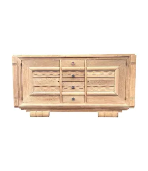 A French 1940s bleached oak sideboard in the style of Charles Dudouyt with two doors and four central drawers and relief front design